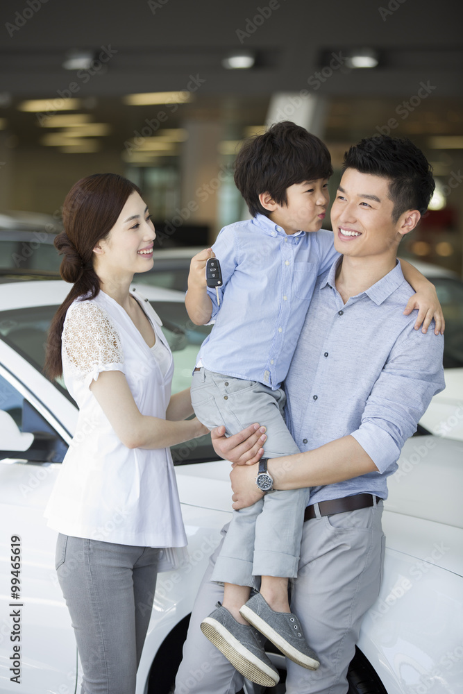 Young family buying car in showroom