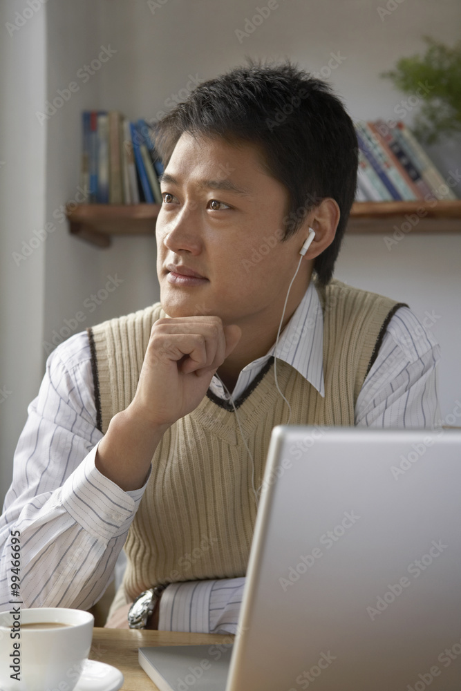 Man Using Laptop Computer With Headphones On