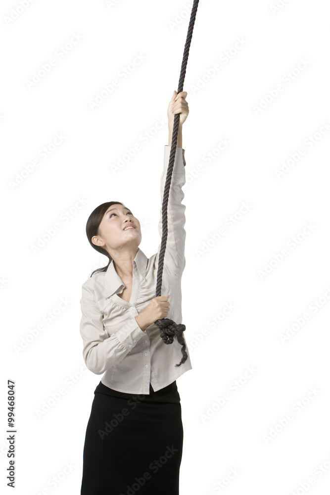 Businesswoman climbing rope