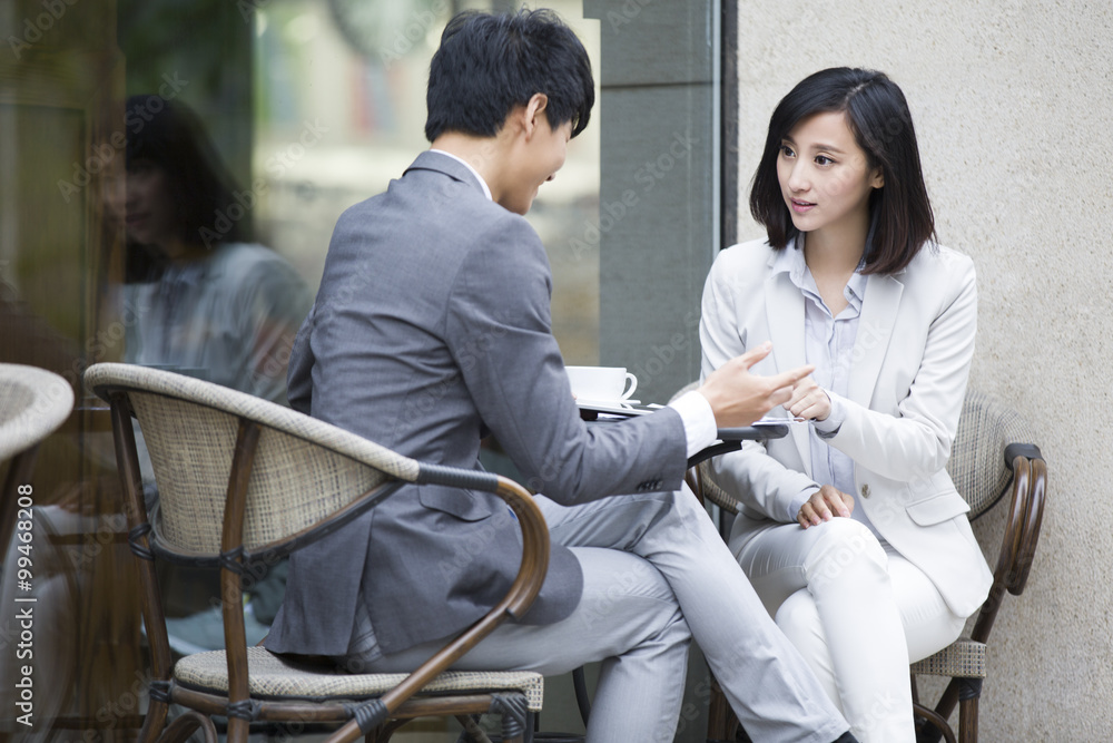 Two business person sitting at outdoor sidewalk café