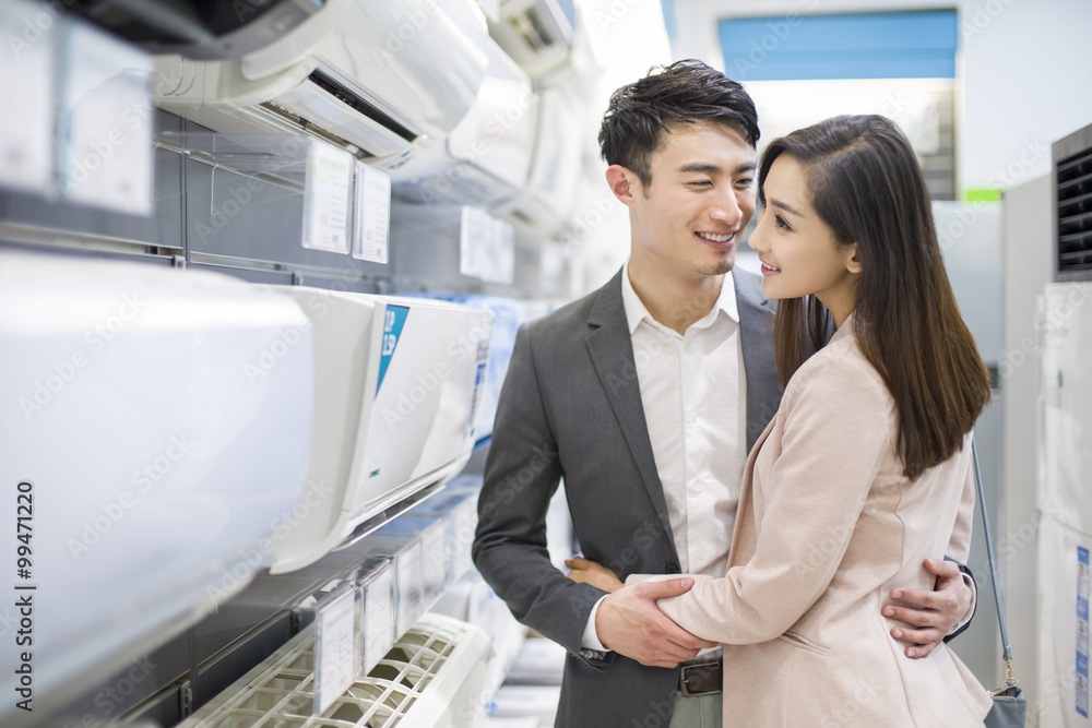 年轻夫妇在电子商店买空调