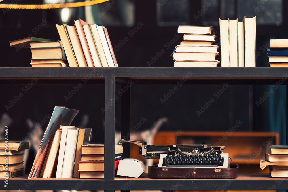 Books and typewriter on wooden shelfs