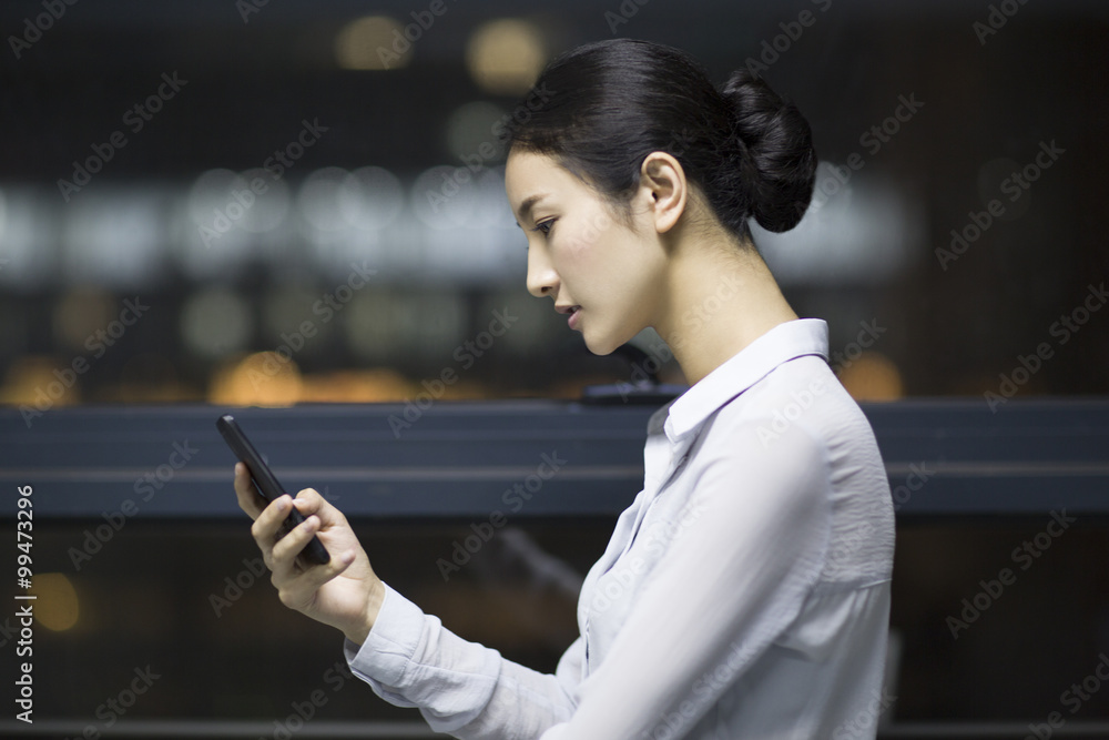 Young businesswoman using smart phone in office