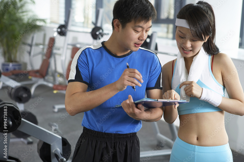 Young Man Instructing Woman At The Gym