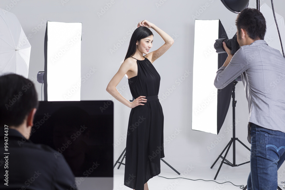 Photographer taking pictures of female model in studio