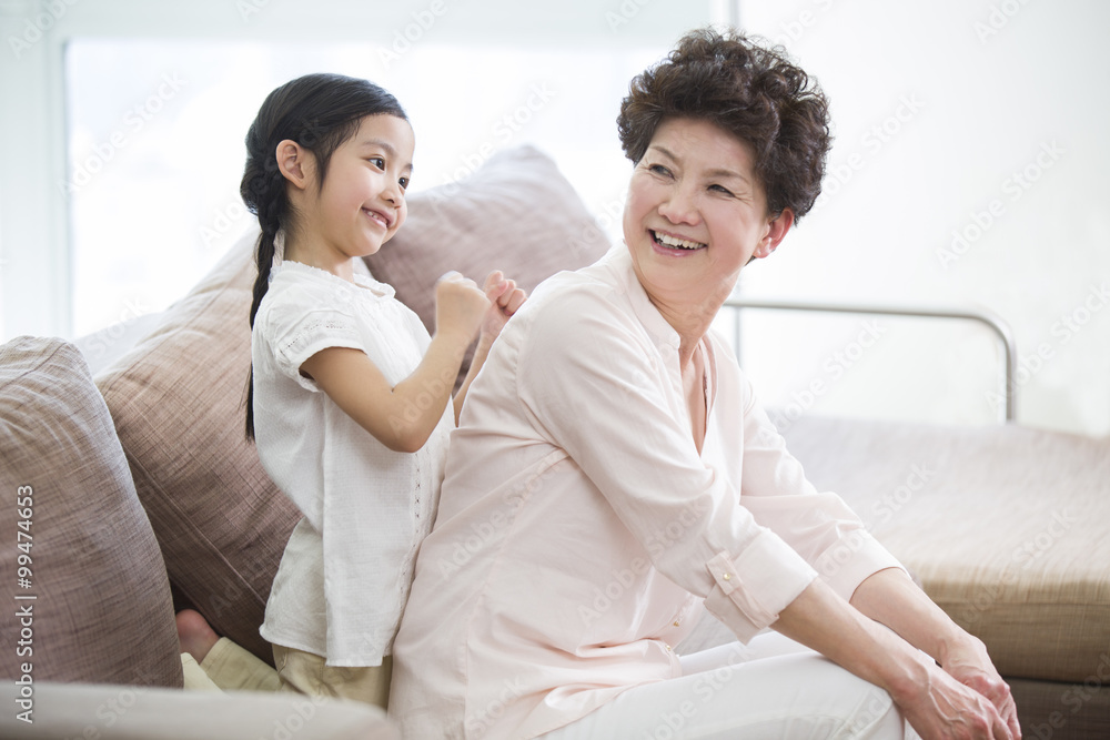 Cute girl massaging grandmothers back