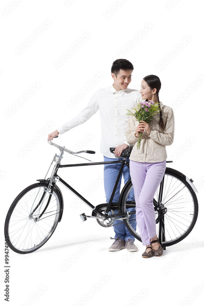 Sweet retro couple with flowers and old-fashioned bicycle