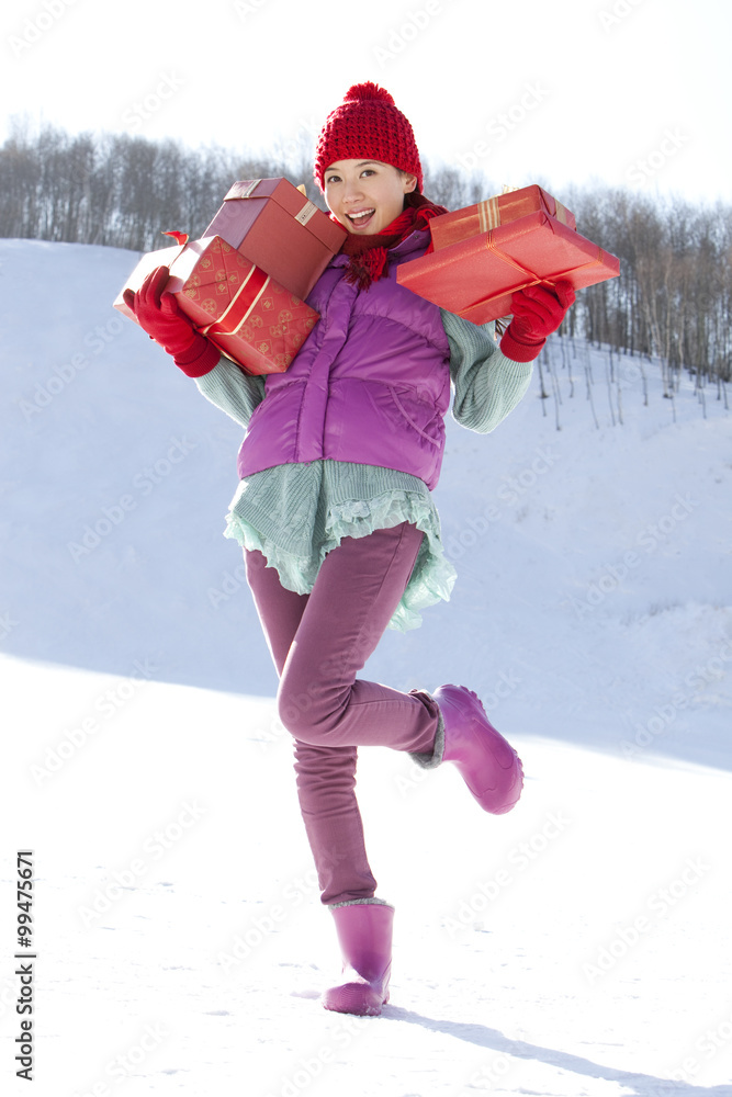 Happy young woman holding gift boxes