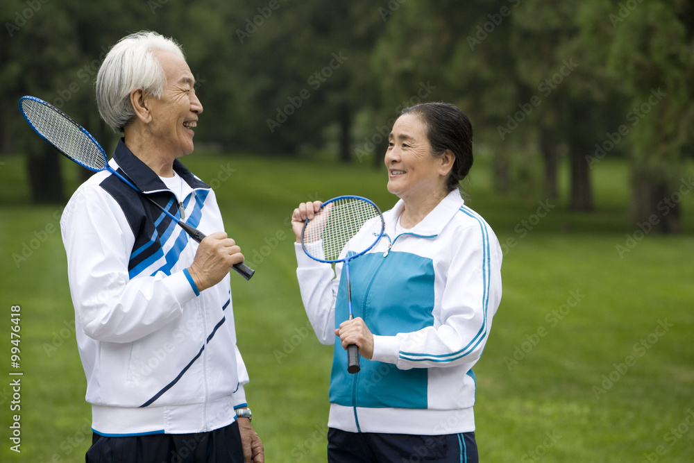 Senior Couple Holding Badminton Rackets in a Park