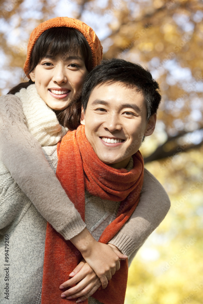 Young Couple Playing in a Park in Autumn