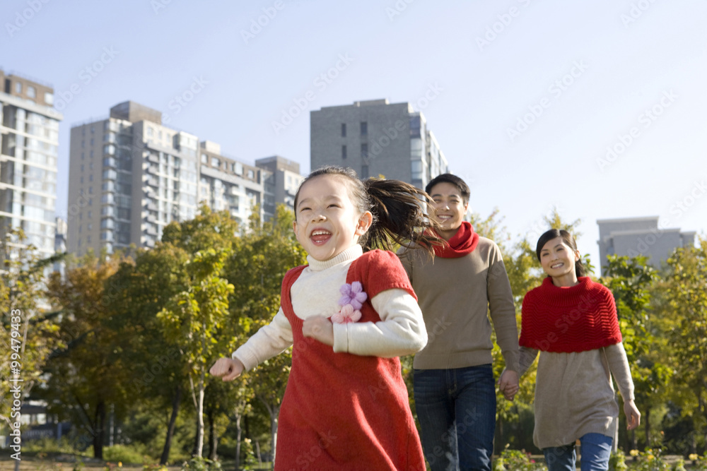 年轻的一家人在秋天享受公园