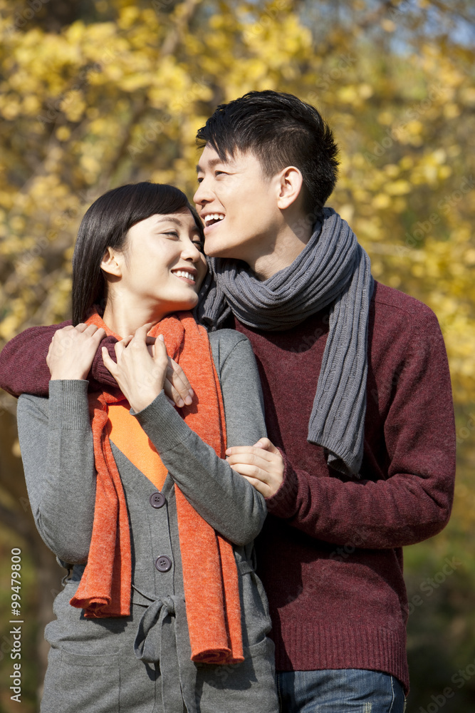 Happy young couple in love arm around outdoors in autumn