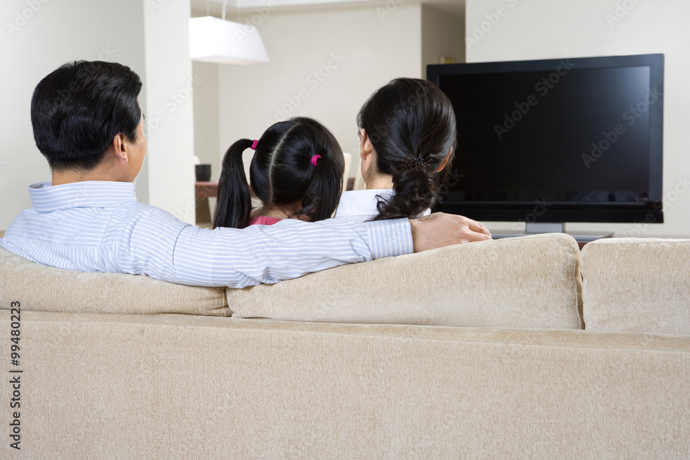 Couple with child in front of widescreen television