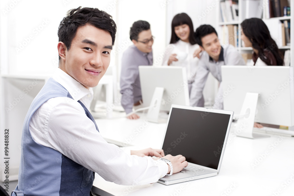 Male office worker using laptop in studio