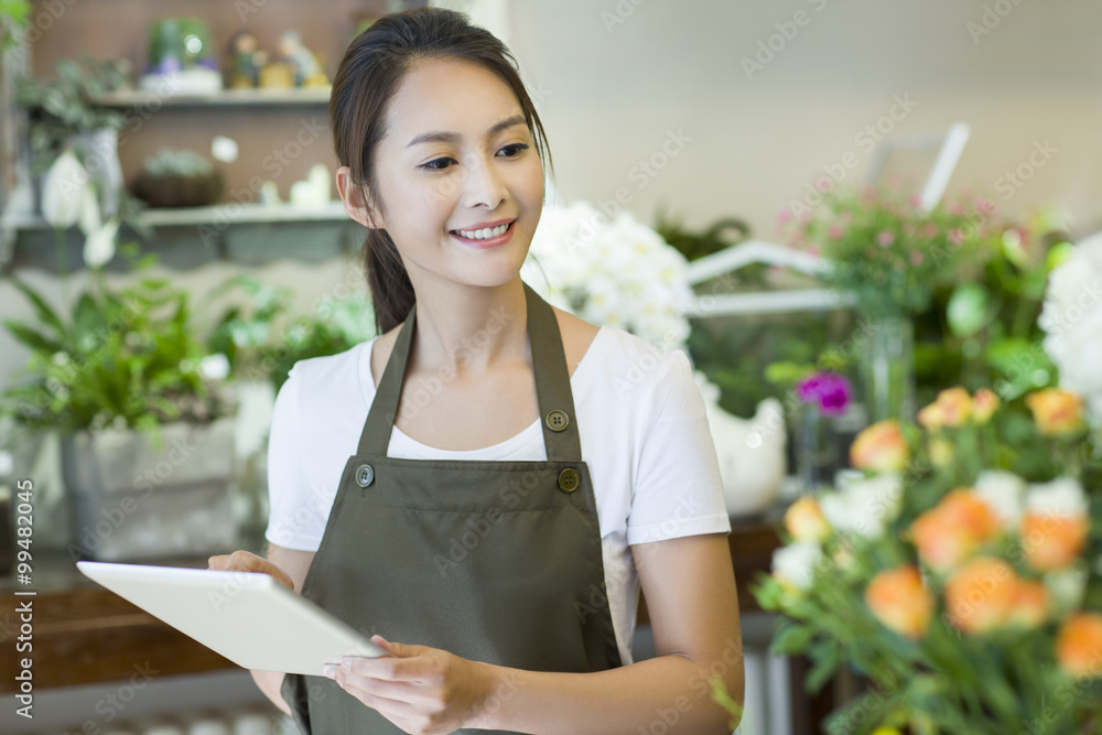 女花商在店里使用数字平板电脑