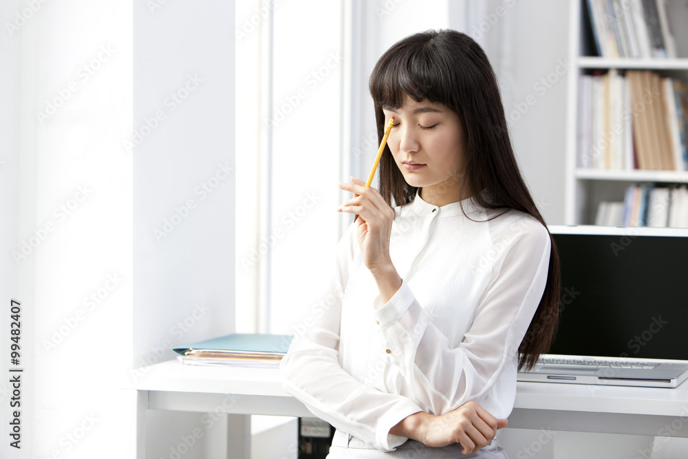 Young businesswoman thinking in the office