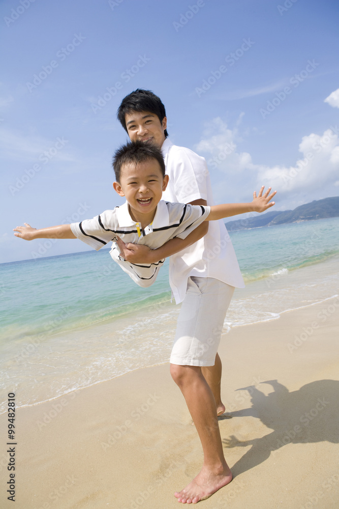 Father and son playing on the beach