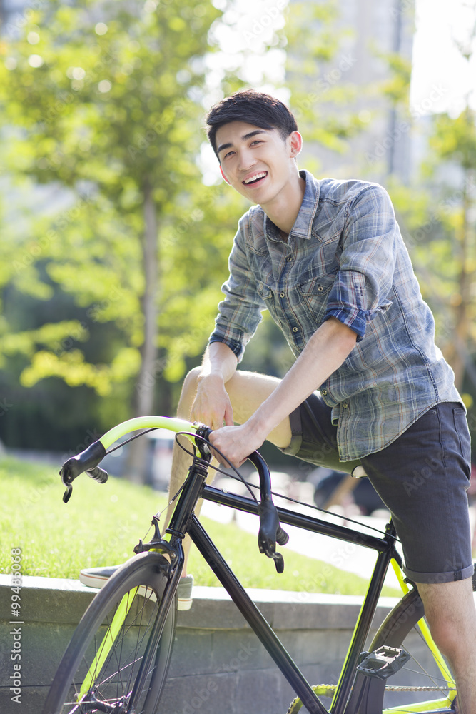 Happy young man riding bicycle