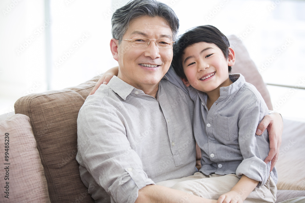 Cute grandson sitting on grandfathers lap