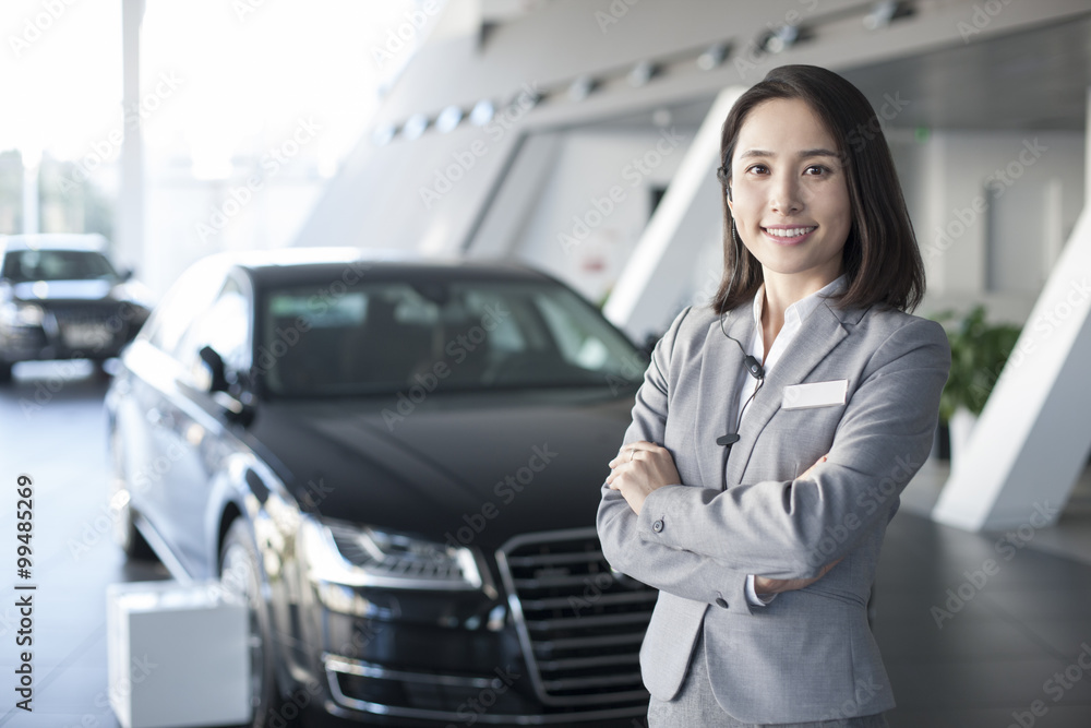 自信的女销售员站在展厅里展示新车