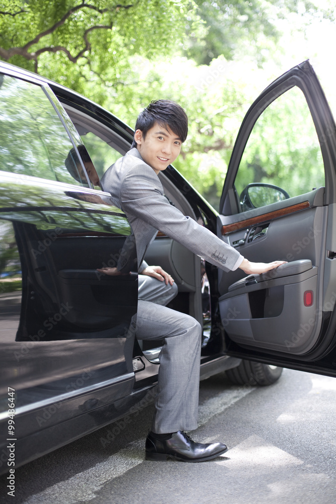 Businessman getting off car