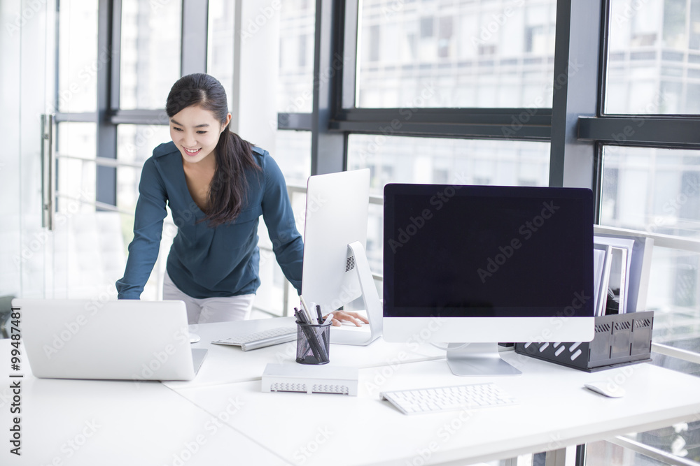 Young businesswoman using laptop in office