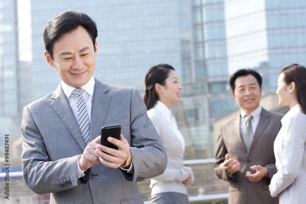 Cheerful businessman text messaging