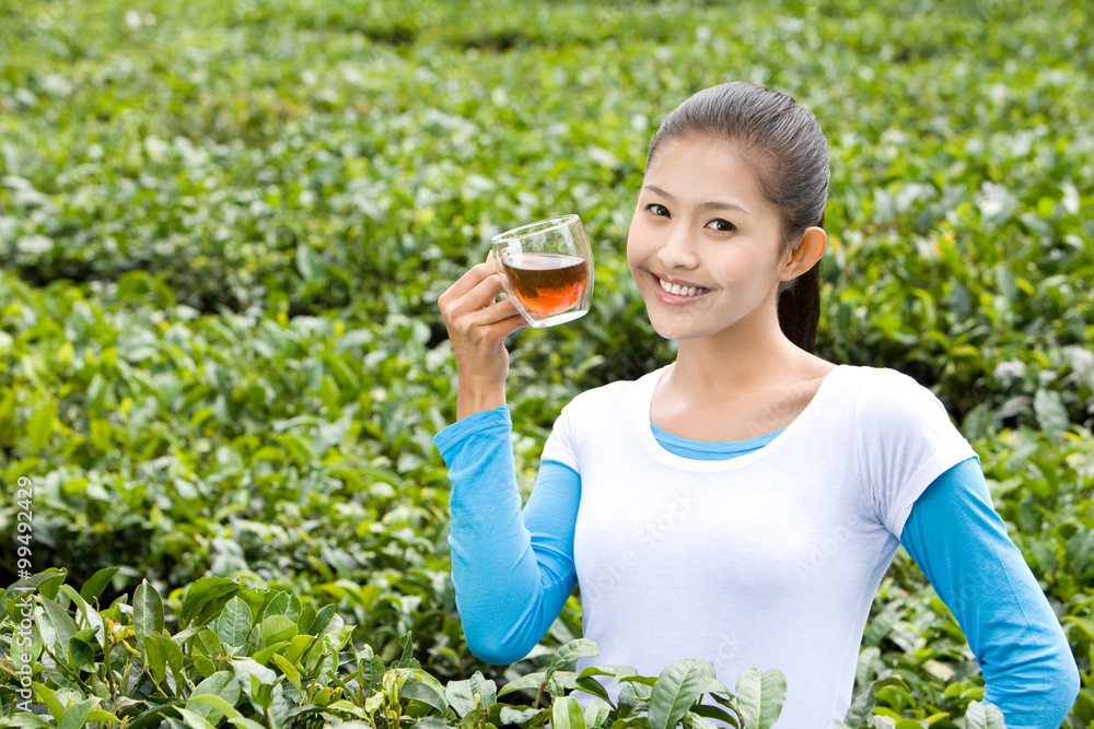 年轻女子在茶园喝茶