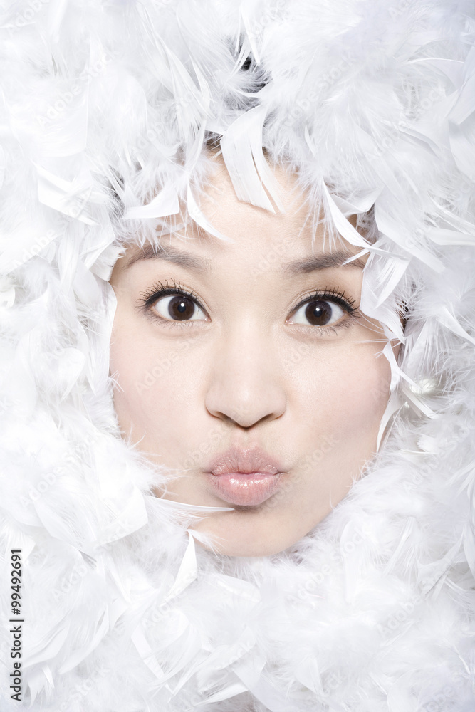 Feathers surrounding the face of young woman