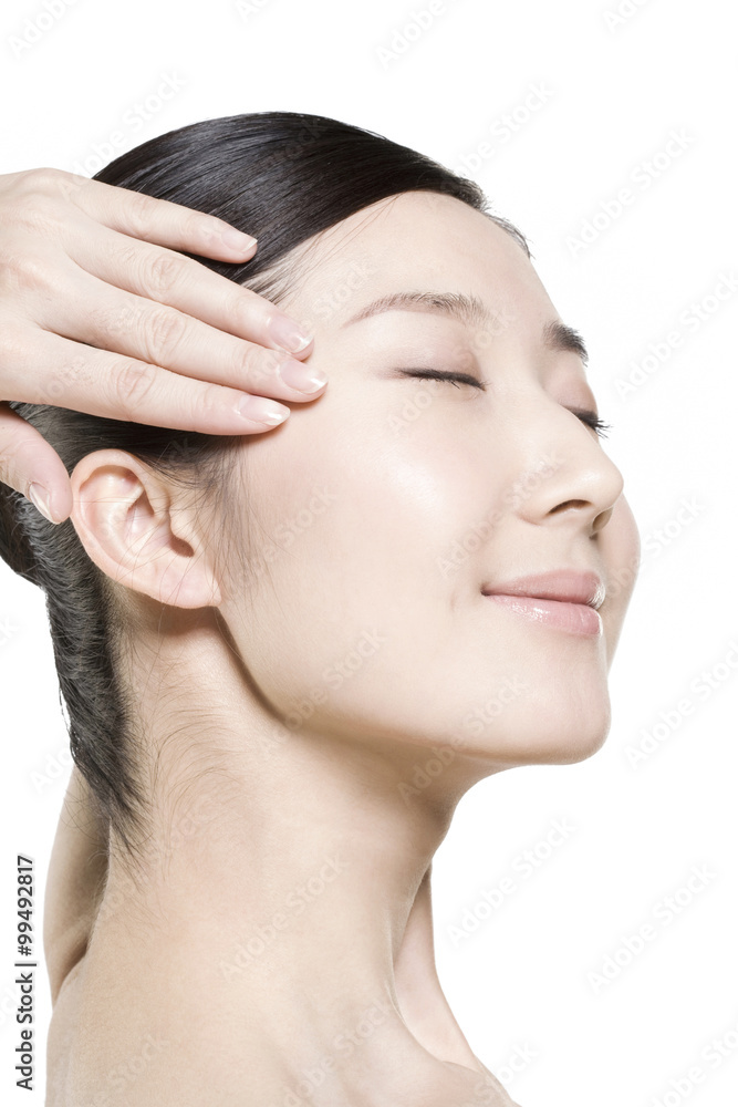 Beauty shot of a young woman touching her face