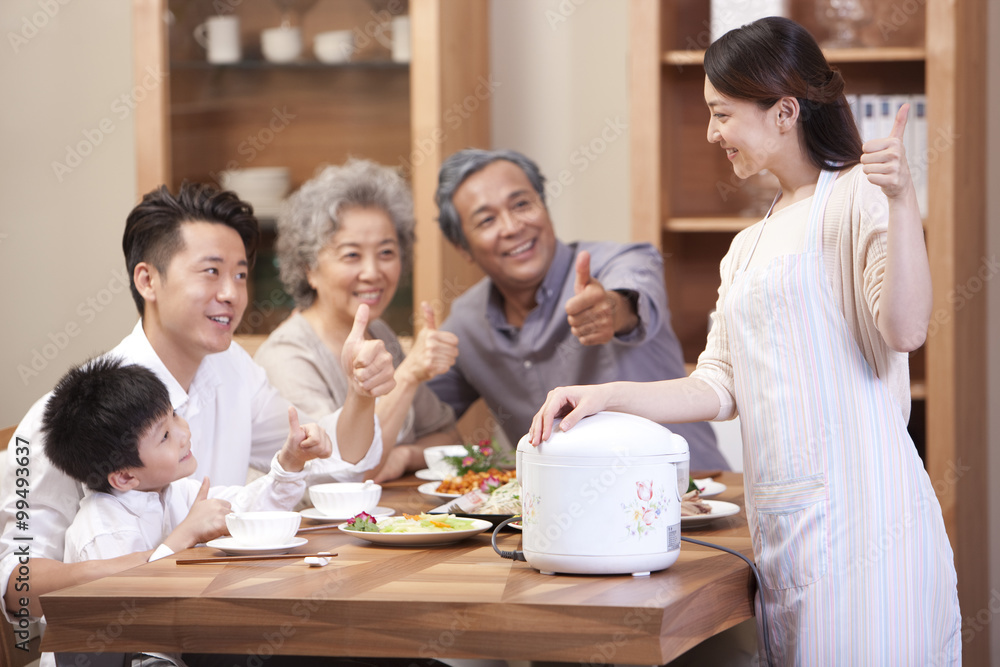 快乐的一家人在用餐时间竖起大拇指