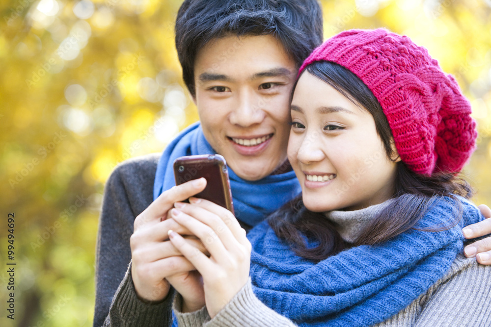 Young Woman Shows Mobile Phone to Young Man