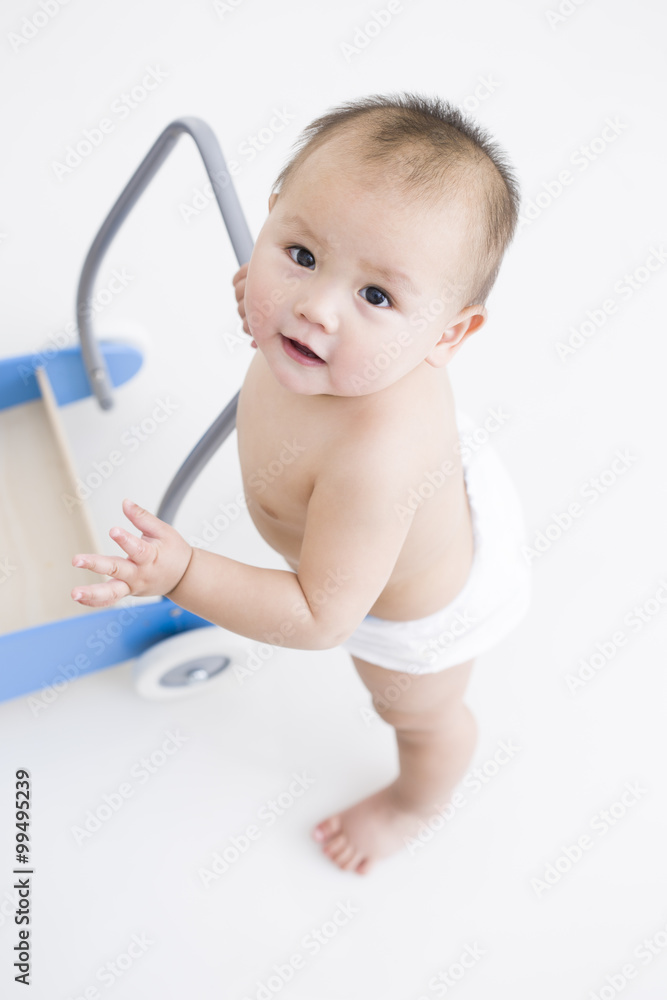 Cute baby boy with push cart