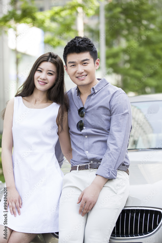 Happy young couple and car