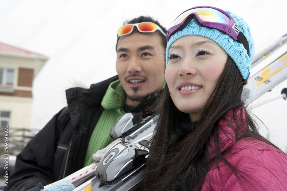 滑雪场上的情侣，手持滑雪