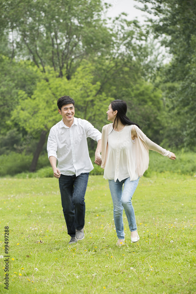 幸福的年轻夫妇牵手跑步