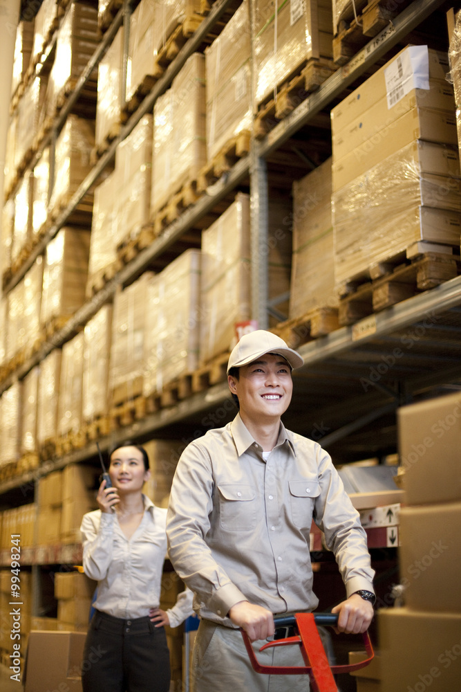 Male Chinese warehouse with Chinese businesswoman in the background