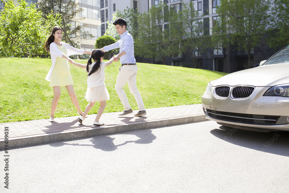 Happy young family playing ring-around-the-rosy outdoors