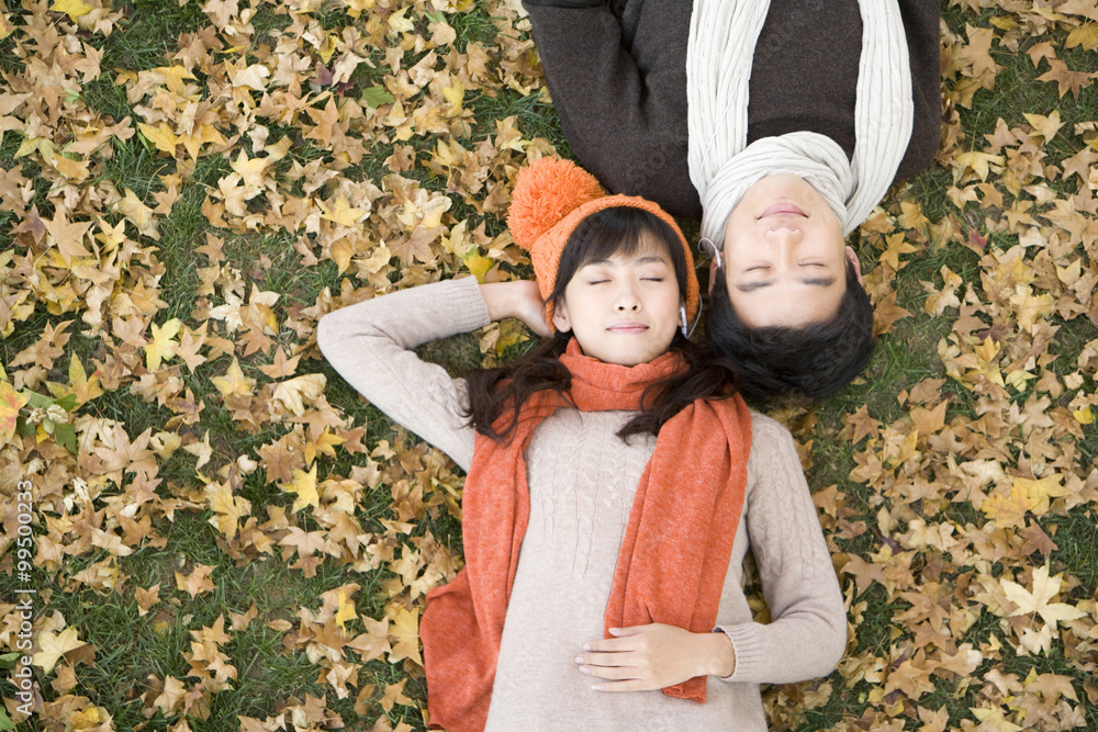 Young Couple Lying Amonst Maple Leaves