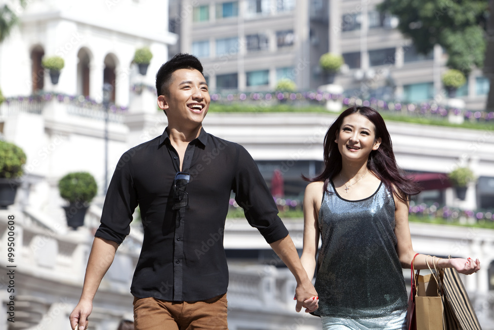 Cheerful young couple with shopping bags enjoying a nice day, Hong Kong