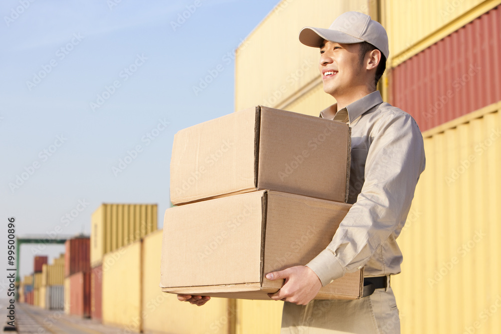 shipping industry worker carrying cardboard boxes