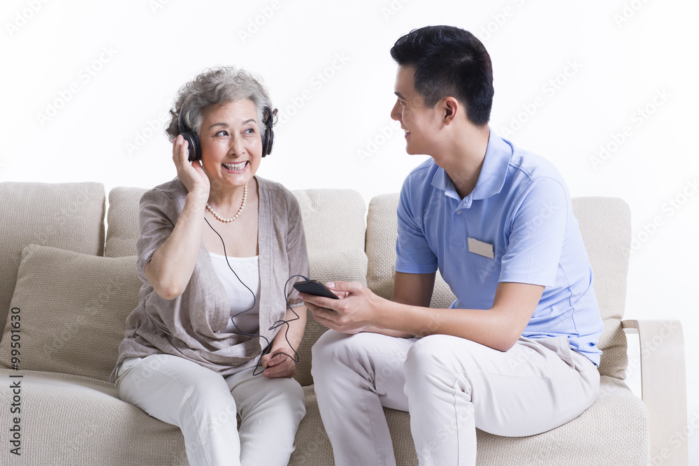 Male nursing worker and senior woman enjoying music