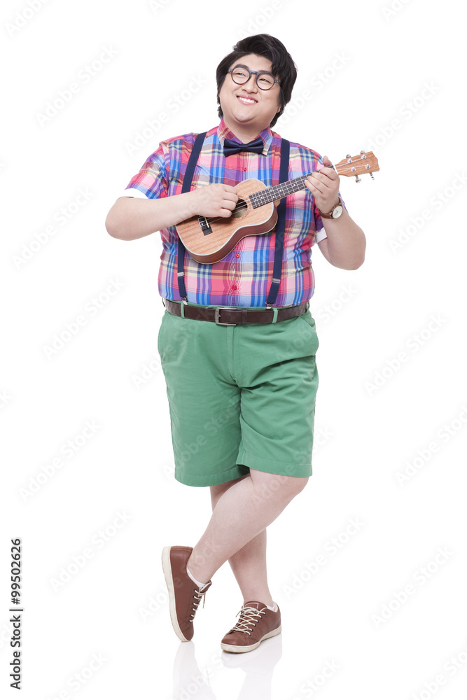 Happy overweight man playing small guitar