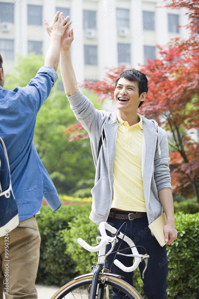 Cheerful college boys high fiving