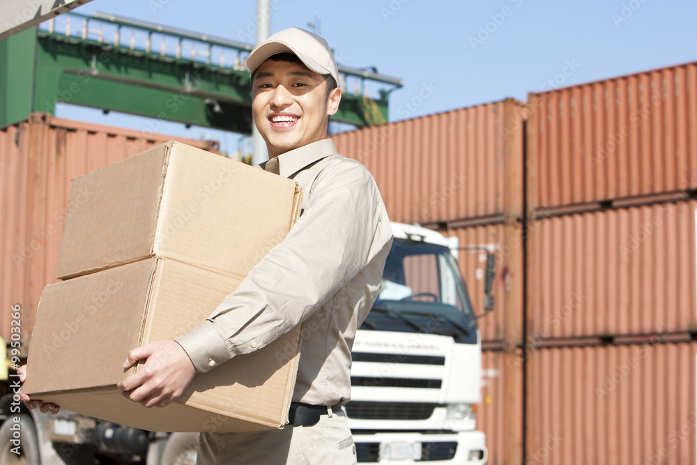 shipping industry worker carrying cardboard boxes