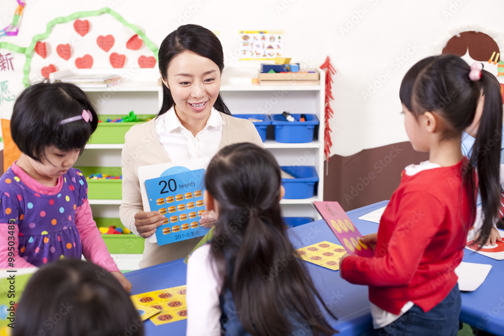 Kindergarten teacher teaching children maths