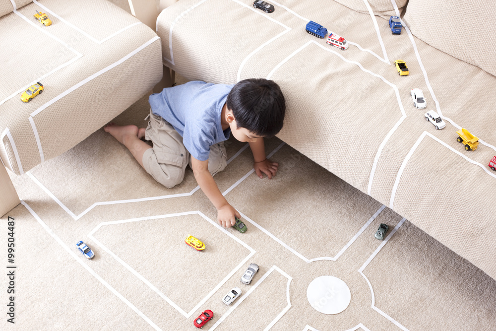 Boy playing toy car at home