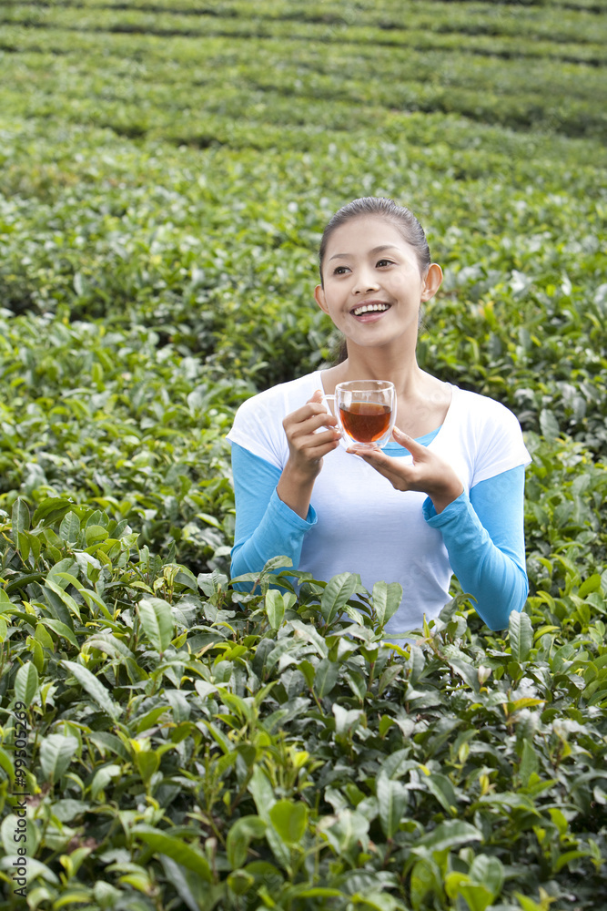 年轻女子在茶园喝茶