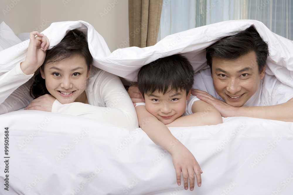 Family hiding under blanket