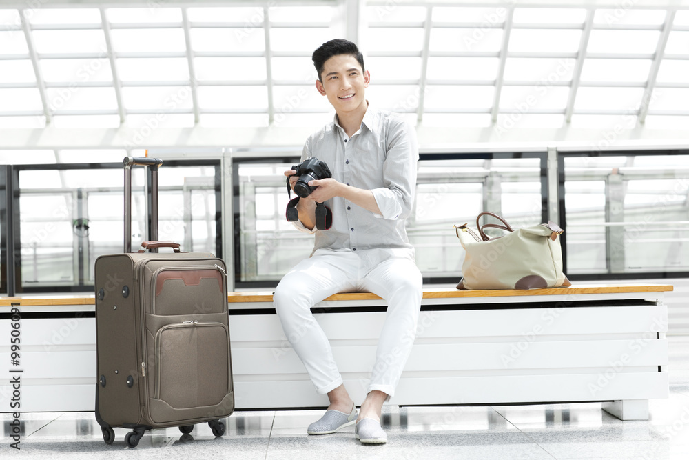 Young man with SLR camera at subway station